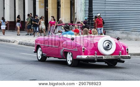 Havana, Cuba - 25 July 2018: A Family Is Being Chauffered Aound In A Beautiful Vintage Pink Chevrole
