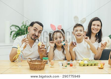 Amicable Mother Father Son And Daughter Are Involved In The Process Of Preparing Fer Easter, Paintin