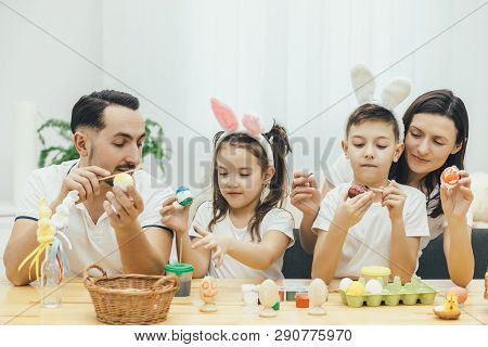 Amicable Mother Father Son And Daughter Are Involved In The Process Of Preparing Fer Easter, Paintin