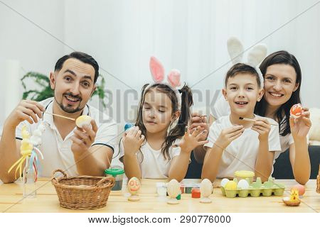 Amicable Mother Father Son And Daughter Are Involved In The Process Of Preparing Fer Easter, Paintin