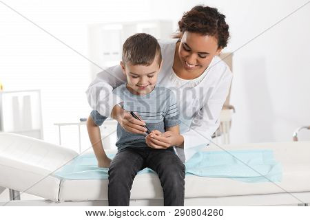 Doctor Taking Patient's Blood Sample With Lancet Pen In Hospital. Diabetes Control