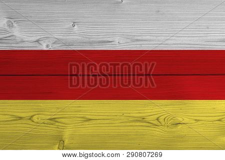 South Ossetia Flag Painted On Old Wood Plank. Patriotic Background. National Flag Of South Ossetia
