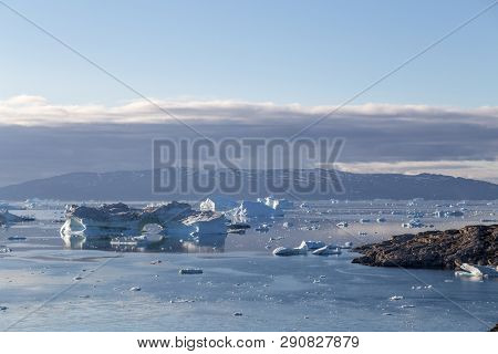 Ilulissat, Greenland - July 9, 2018: The Coastline And Icebergs During Midnight Sun. Rodebay, Also K