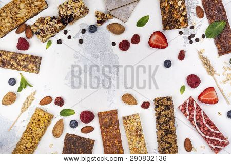 Assortment Of Different Granola Cereal Bars On White Stone Background. Healthy Pre Or Post Workout S