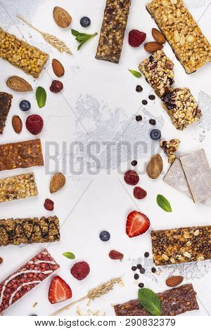 Assortment Of Different Granola Cereal Bars On White Stone Background. Healthy Pre Or Post Workout S