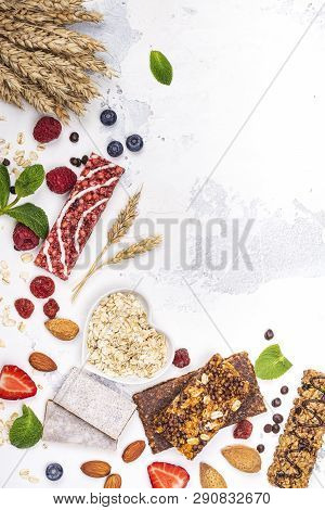 Assortment Of Different Granola Cereal Bars On White Stone Background. Healthy Pre Or Post Workout S