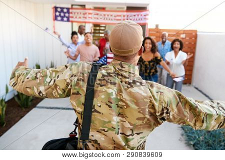 Three generation black family welcoming millennial soldier returning home,back view, focus on foreground