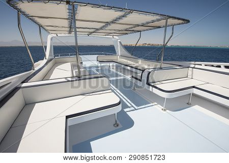 Sundeck Area Of A Large Luxury Motor Yacht With Chairs Sofa Table And Tropical Sea View Background