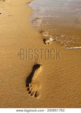 Lonely Footprint At The Beach. Trace At Sand And Sea Wave. Peaceful Lonely Mood. Psychology Or Phylo