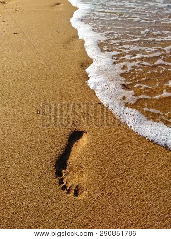 Lonely Footprint At The Beach. Trace At Sand And Sea Wave. Peaceful Lonely Mood. Psychology Or Phylo