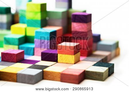 Spectrum of stacked multi-colored wooden blocks. Background or cover for something creative, diverse, expanding,  rising or growing. shallow depth of field.