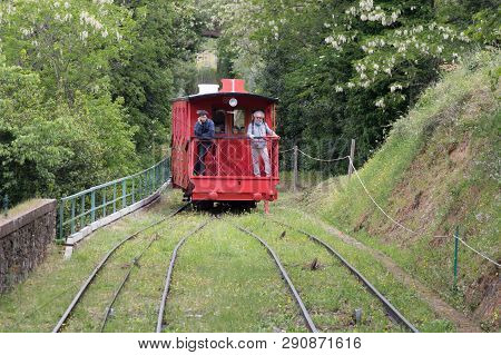 Italy, Montecatini Terme - April 25 2017: The View Of Red Funicular And Railroad Through Green Trees