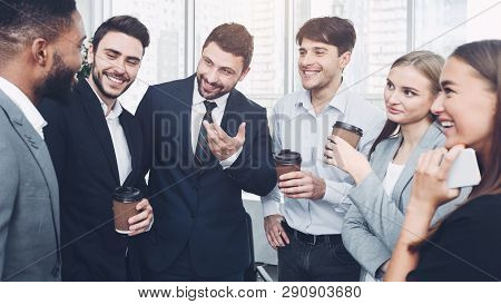 Happy Colleagues Talking, Having Coffee Break During Worktime In Office