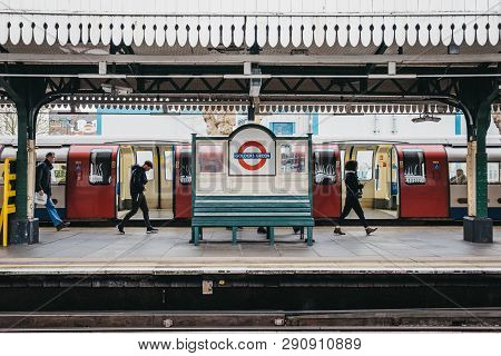 London, Uk - March 16, 2019: People Walking Past The Station Name Sign On The Outdoor Platform Of Go