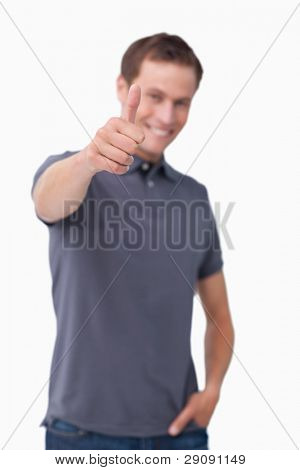 Pollice su dato da sorridente giovane contro uno sfondo bianco