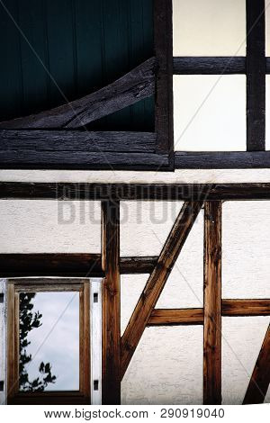 The Beam Construction And The Wooden Framework Of A Nostalgic Half-timbered House With A Yellowed Fa