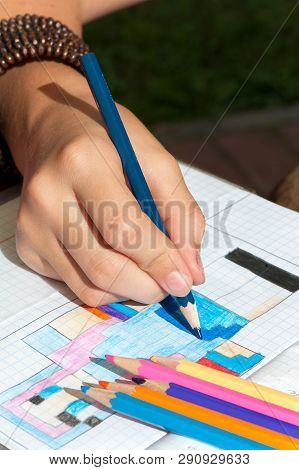Child Hand Draws The Multicolored Minecraft Picture. Close-up Vertical Image