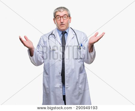 Handsome senior doctor man over isolated background clueless and confused expression with arms and hands raised. Doubt concept.