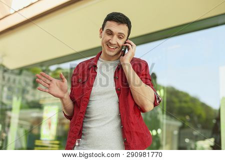 Joyful Man In Red Shirt Talking By Telephone