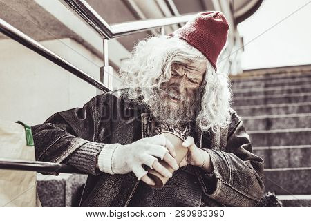 Almsman Sitting And Counting Small Money Received Per Day.