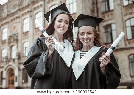 Positive Delighted Leavers Standing Over University Background