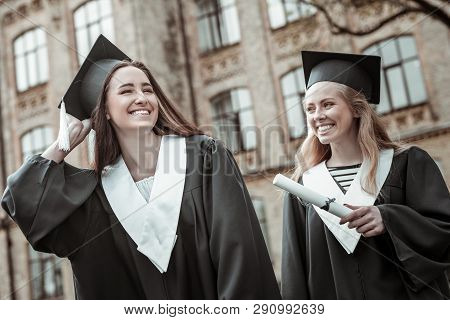 Pleased Pretty Students Wearing Black Graduation Uniform