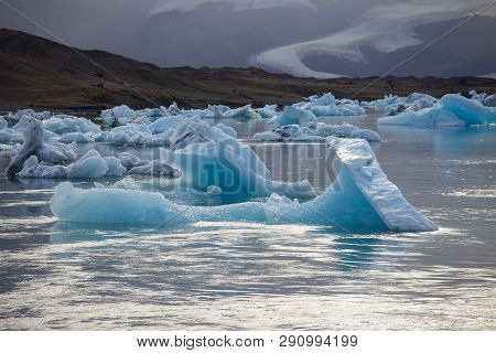 Amazing Transparent Blue Iceberg Pieces In Jokulsarlon Lagoon, Iceland. Ice Calving.