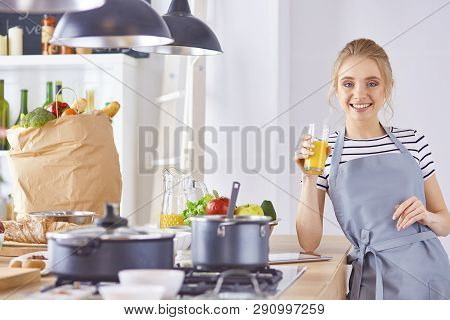 The Girl At The Table In The Kitchen With A Glass Of Orange Jui