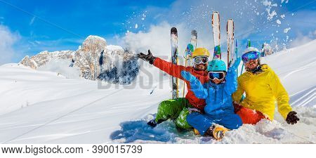 Skiing family enjoying winter vacation on snow in sunny cold day in mountains and fun. San Martino di Castrozza, Italy.