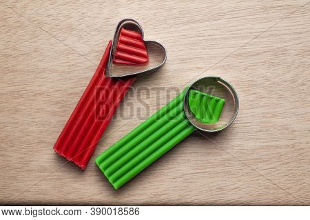 Several Pieces Of Plasticine Lie On A Wooden Board With Cutting Molds