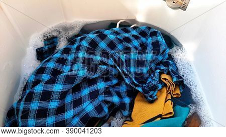 Colorful Cloths Loaded In Top Load Washing Machine With Detergent Added Water