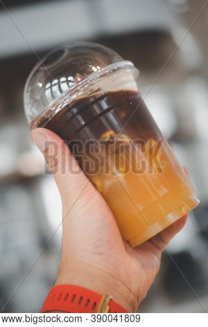 Iced Orange Juice And Passion Fruit Mix Black Cold Brew Coffee In Hand. Fusion Coffee And Summer Dri