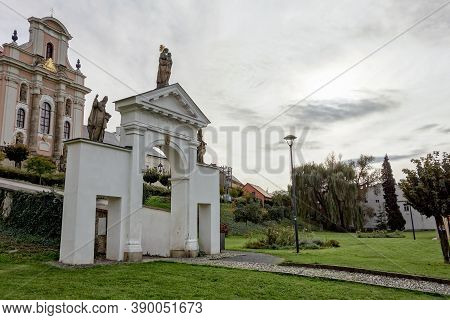 The White Baroque Entrance Gate In Fulnek, Czech Republic With A Kostel Nejsvetejsi Trojice (holy Tr