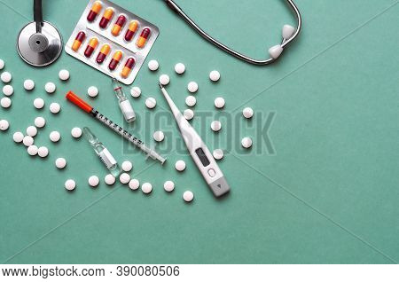 Pills, Ampoule, Syringes, Capsules, Stethoscope On The Green Doctor S Table.copy Space.