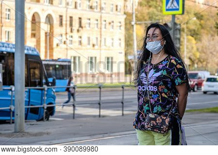 Moscow. Russia. October 4, 2020. An Adult Woman In A Protective Medical Mask Stands At A Bus Stop Wa