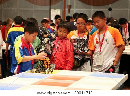 SUBANG JAYA - NOVEMBER 10: Unidentified elementary students prepare their robot for the 'robot organizer' challenge at the World Robot Olympaid on November 10, 2012 in Subang Jaya, Malaysia.