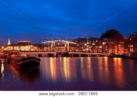 Malebné město od Amsterdamu s Thiny bridge v noci v Nizozemsku