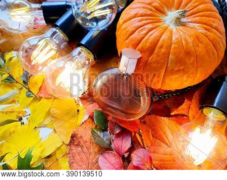 Perfume Bottle, Pumpkin And Magic Lights On Bright Autumn Leaves. Eau De Toilette. Fall Flatlay, Moc