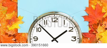 Plain Wall Clock In The Center Of Autumn Orange Red Leaves And Fall Foliage. Two Oclock. Copy Space,