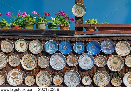 Romanian Traditional Ceramic Plates From Horezu Area, Romania, Placed Ornamentally On A Rustic Woode