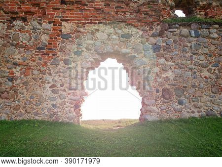 A Bright Ray Of Sun Shines Through The Arch Of An Ancient Stone Wall. There Is An Empty Space To Wri