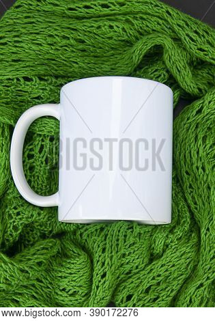 White Coffee Cup In Green Lace Scarf With Copyspace On The Coffee Mug Nestled In A Handknit Scarf.