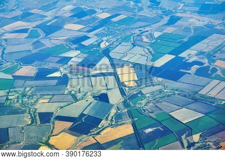 Aerial View Of A Densely Populated Region With Multi-colored Fields And Settlements