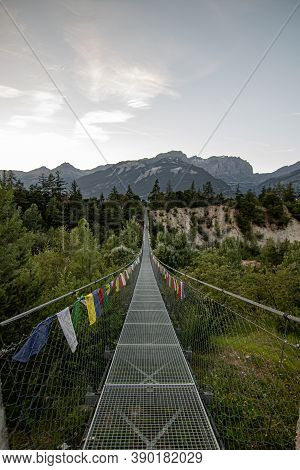 Wooden Long Footbridge Above The Deep Gorge With A River Beach At The Bottom, Between The Rocks. Wil