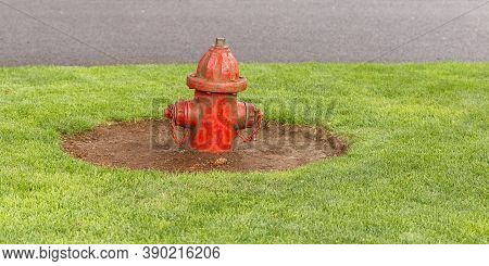Red Old Shabby Fire Hydrant On A Green Grass Lawn