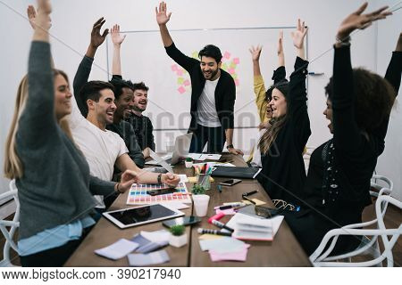 Happy Business Team Celebrating With Raised Up Hands In The Office. Success And Winning Concept.