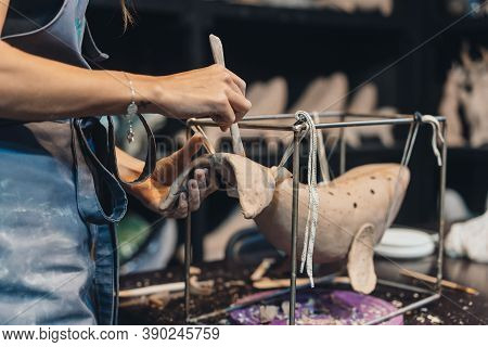 Close-up View Of Female Hands Gently Handling A Clay Whale In Workshop.