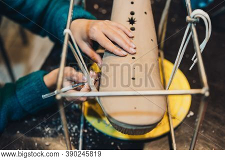 Close-up View Of Female Hands Gently Handling A Clay Whale In Workshop.