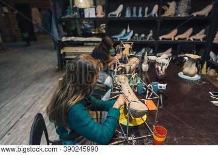 People Carefully Work On Clay Whales In Workshop