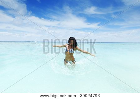 Vrolijke vrij jonge vrouw splashin in zee